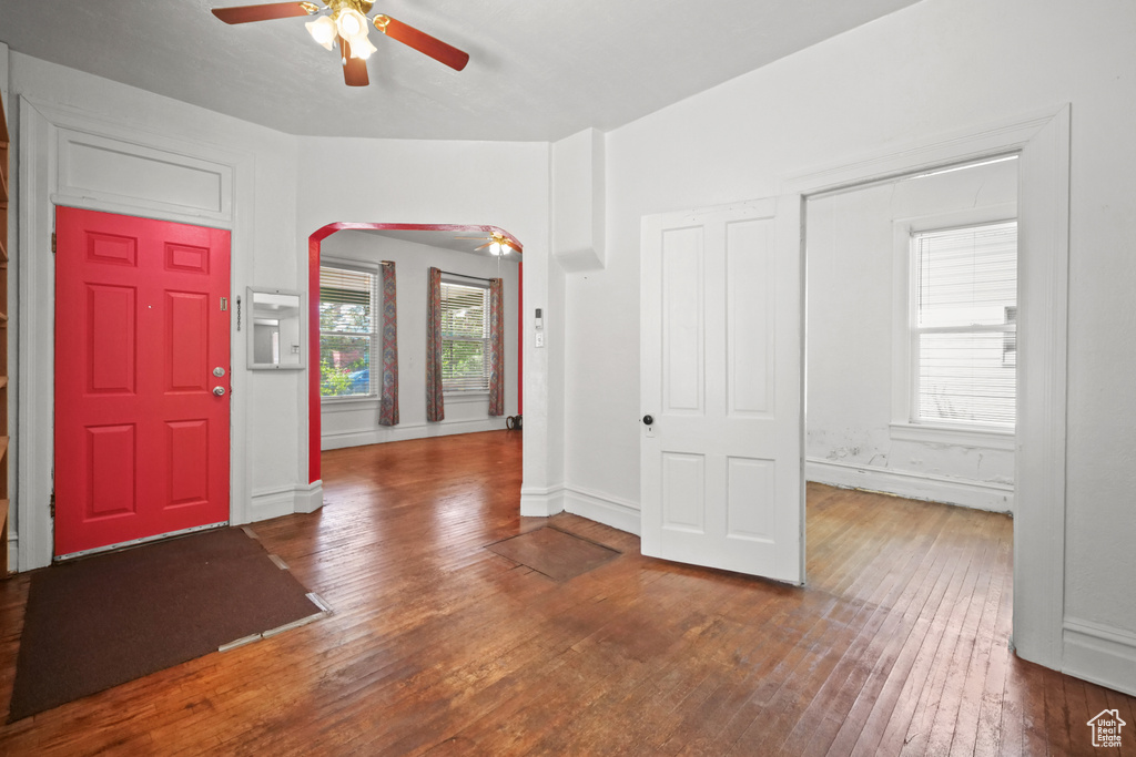 Foyer entrance featuring a ceiling fan, hardwood / wood-style floors, arched walkways, and baseboards