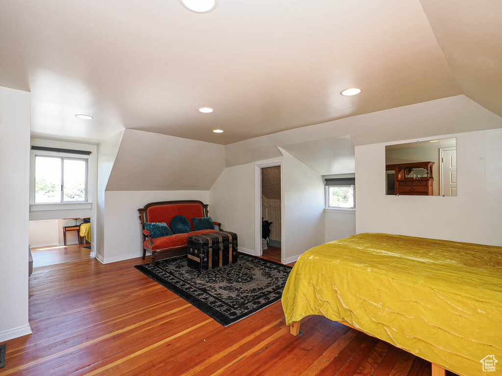 Bedroom with hardwood / wood-style flooring, lofted ceiling, multiple windows, recessed lighting, and baseboards