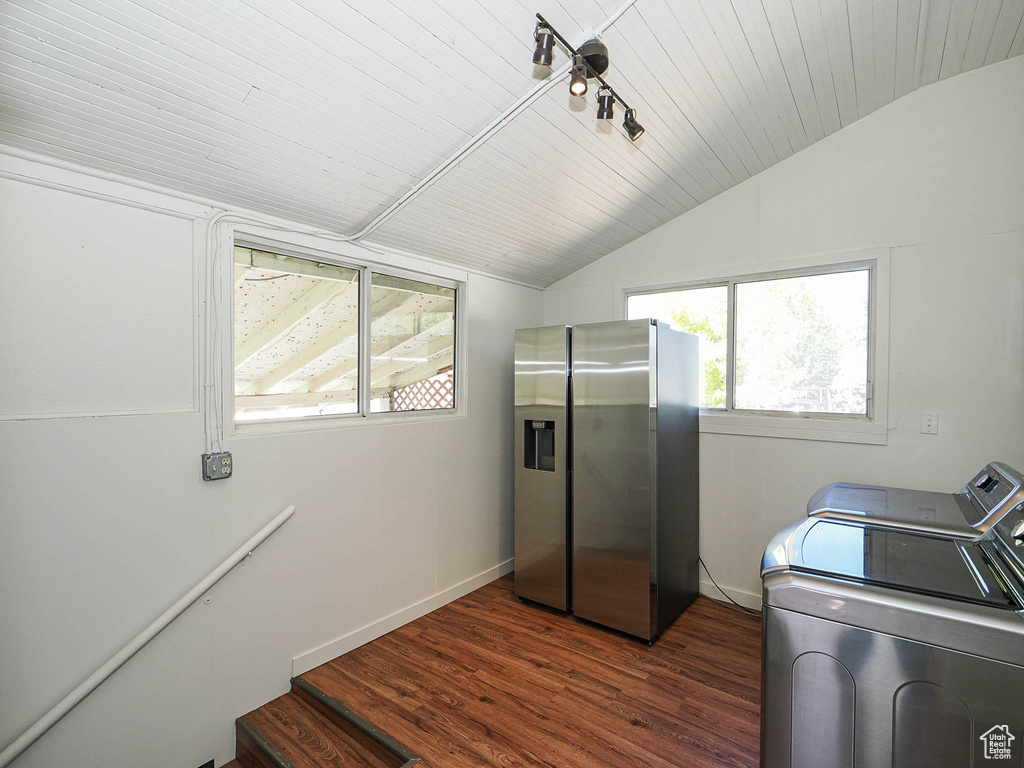 Laundry room with independent washer and dryer, dark wood-style flooring, and baseboards