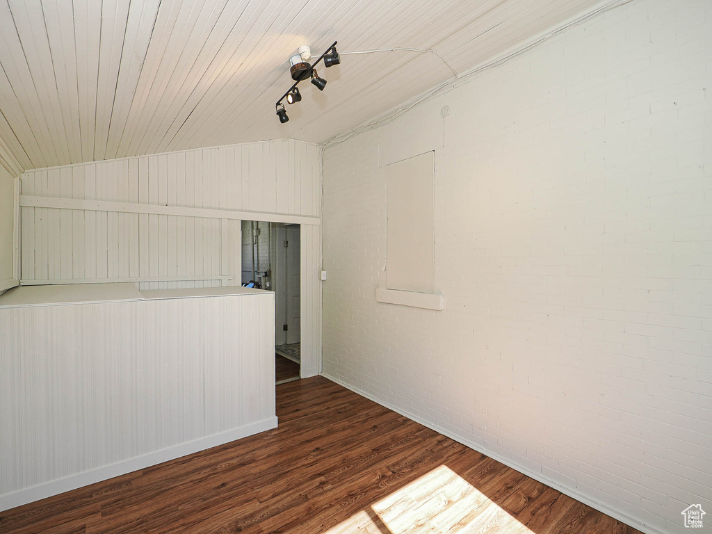 Unfurnished room with wood finished floors and lofted ceiling