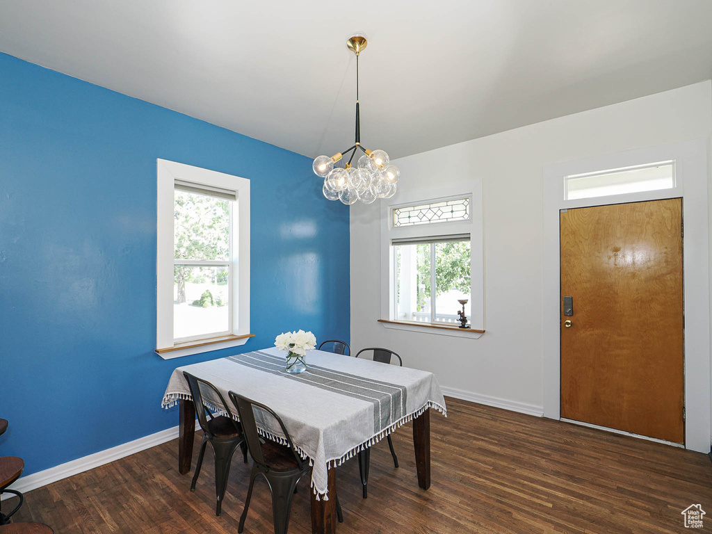 Dining space featuring a chandelier, plenty of natural light, wood finished floors, and baseboards
