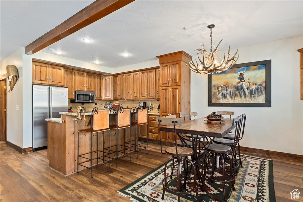 Dining space with baseboards, dark wood-type flooring, a chandelier, and recessed lighting