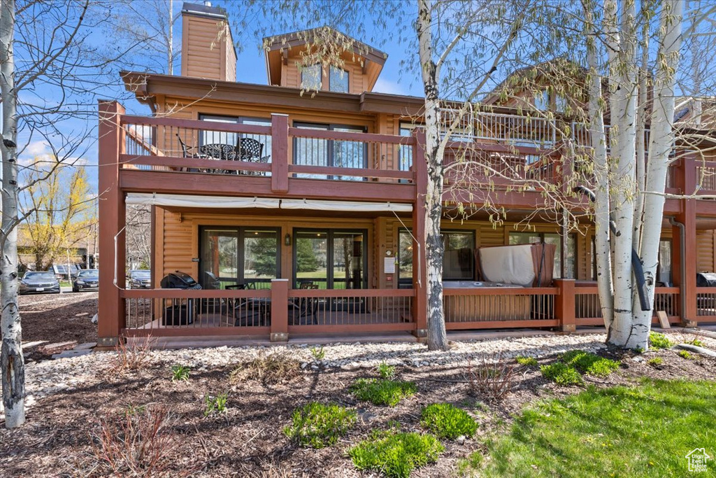Rear view of house with a chimney and a deck