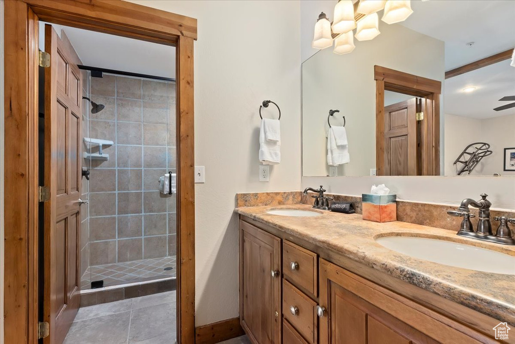 Bathroom featuring a shower stall, double vanity, and tile patterned flooring