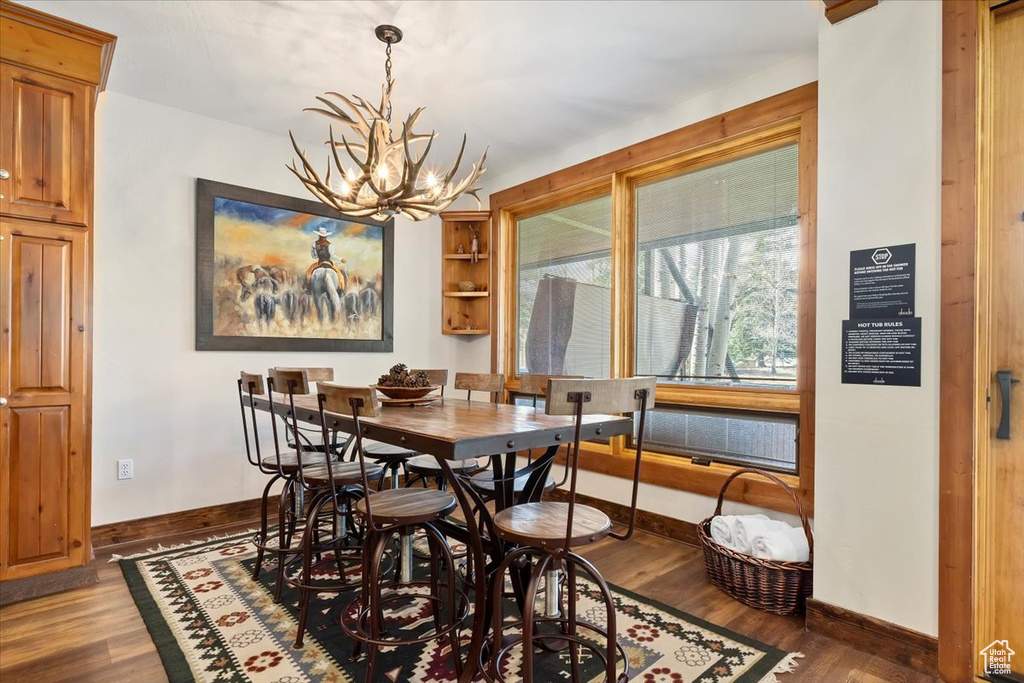 Dining area featuring baseboards, a chandelier, and wood finished floors
