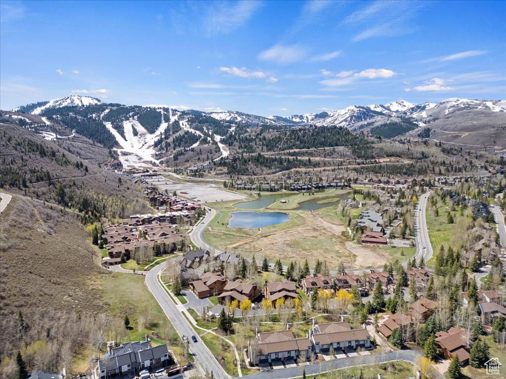 Aerial view of property and surrounding area featuring a water and mountain view and nearby suburban area