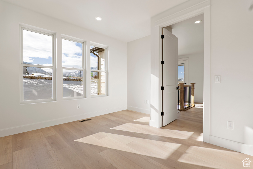 Unfurnished room featuring light wood-type flooring, baseboards, and recessed lighting