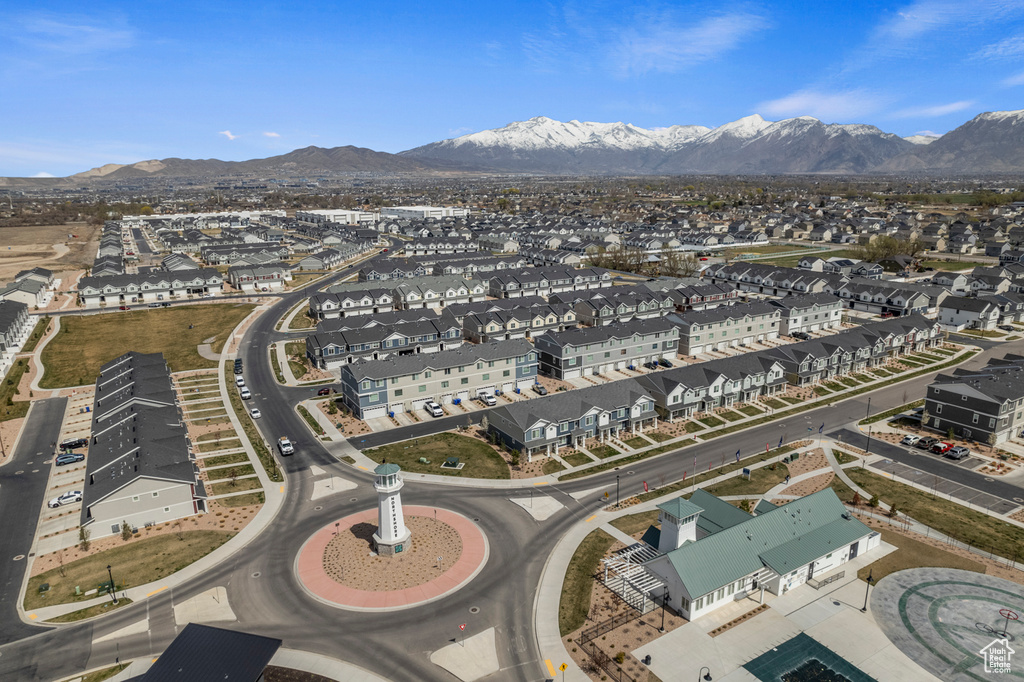 Aerial view of property and surrounding area featuring a mountainous background and nearby suburban area