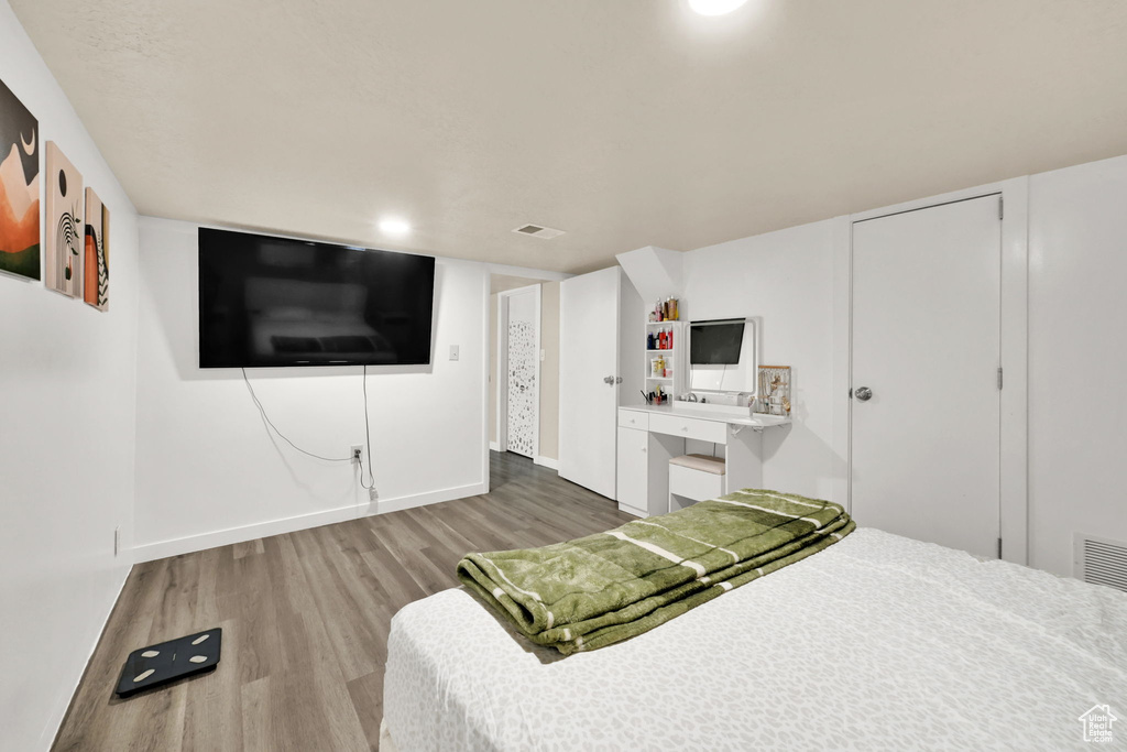 Bedroom featuring wood finished floors and baseboards