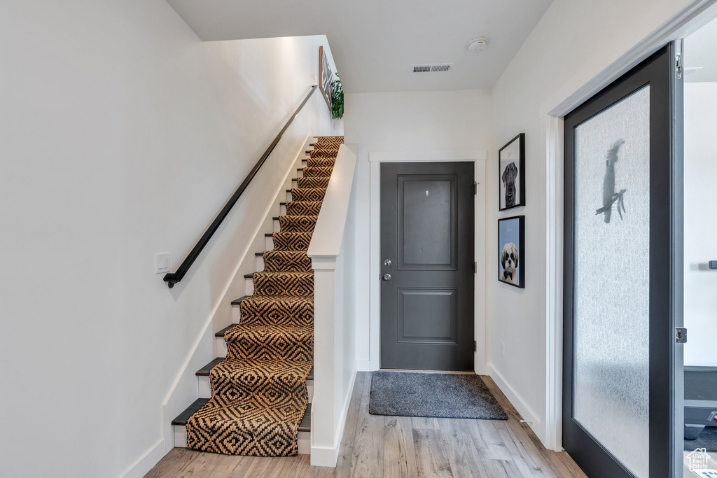Staircase with wood finished floors and baseboards