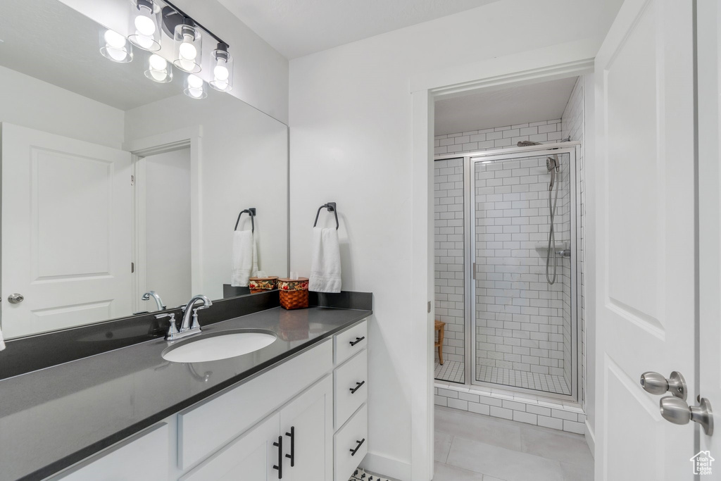 Bathroom with vanity, a stall shower, and tile patterned flooring