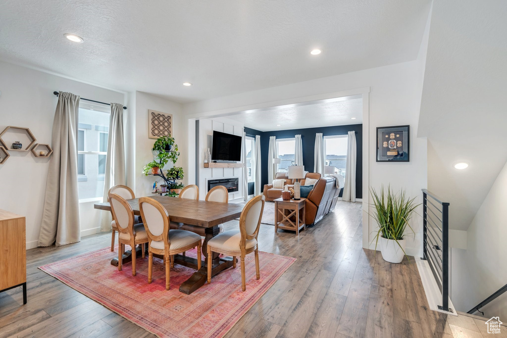 Dining space featuring a fireplace, wood finished floors, baseboards, and recessed lighting