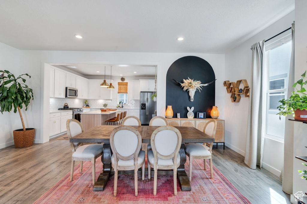 Dining space featuring light wood finished floors, baseboards, and recessed lighting