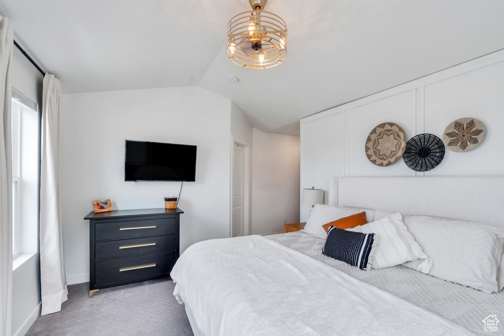 Bedroom with vaulted ceiling and light colored carpet