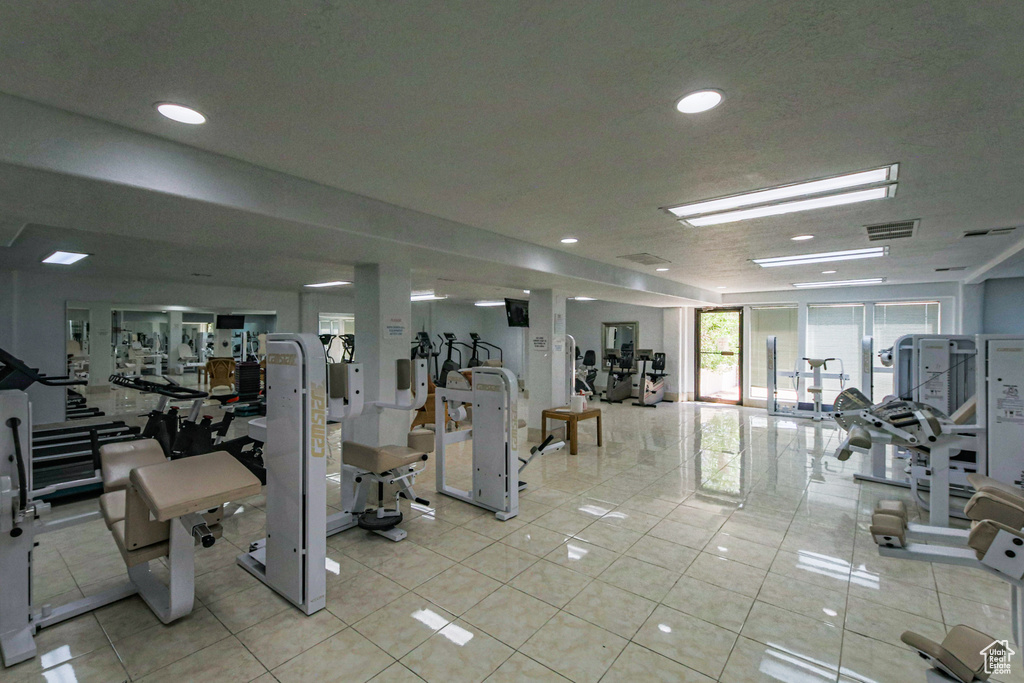 Gym with light tile patterned flooring and recessed lighting
