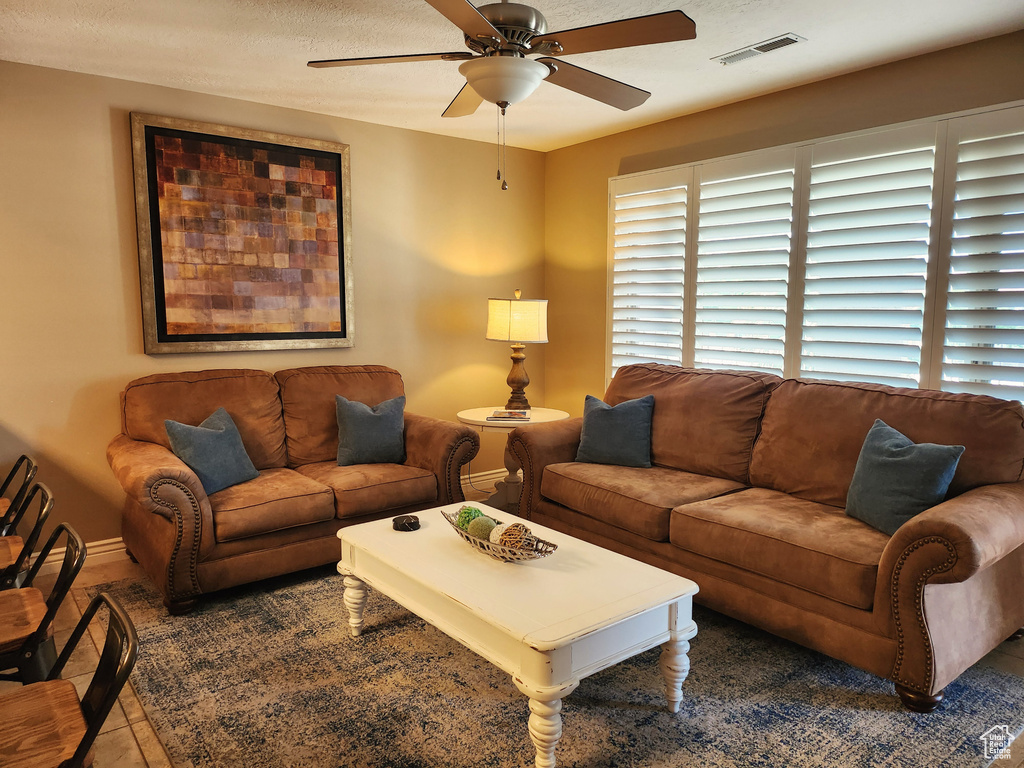 Living area featuring a ceiling fan and baseboards