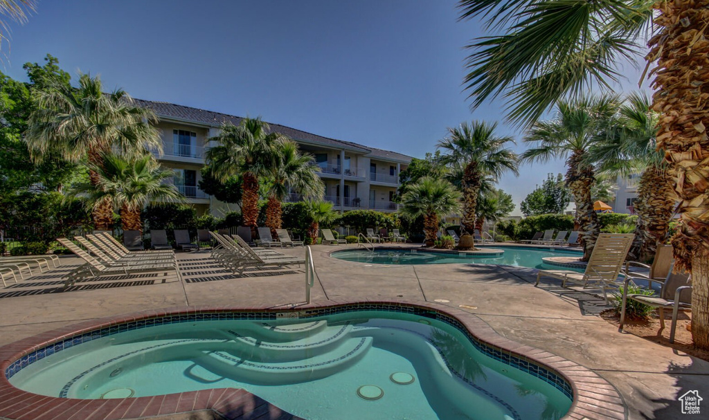 Community pool with a patio area and a hot tub