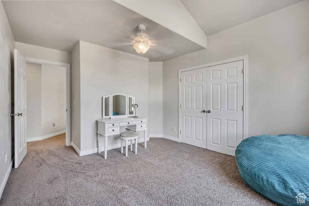 Carpeted bedroom featuring baseboards, ceiling fan, and a closet