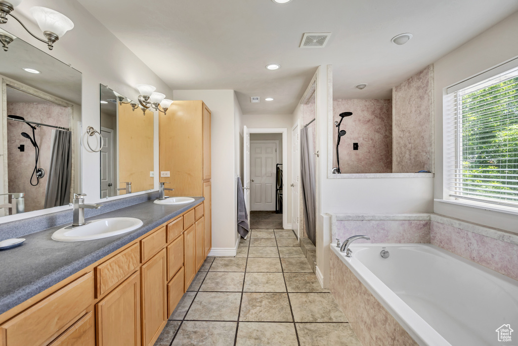 Bathroom with a tile shower, a garden tub, double vanity, tile patterned flooring, and recessed lighting
