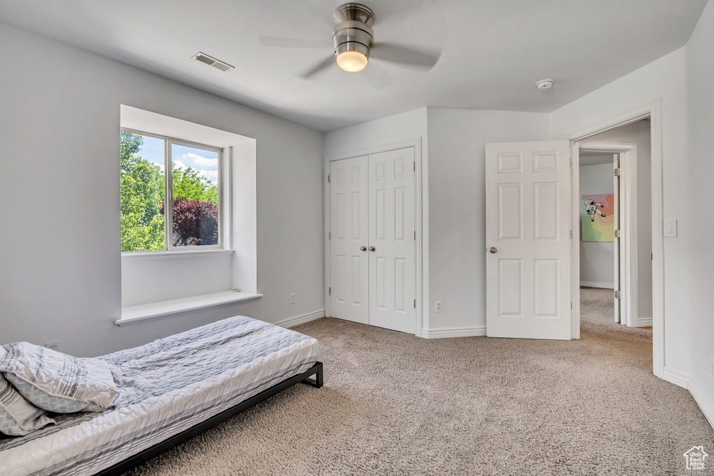 Bedroom with carpet flooring, a closet, baseboards, and ceiling fan