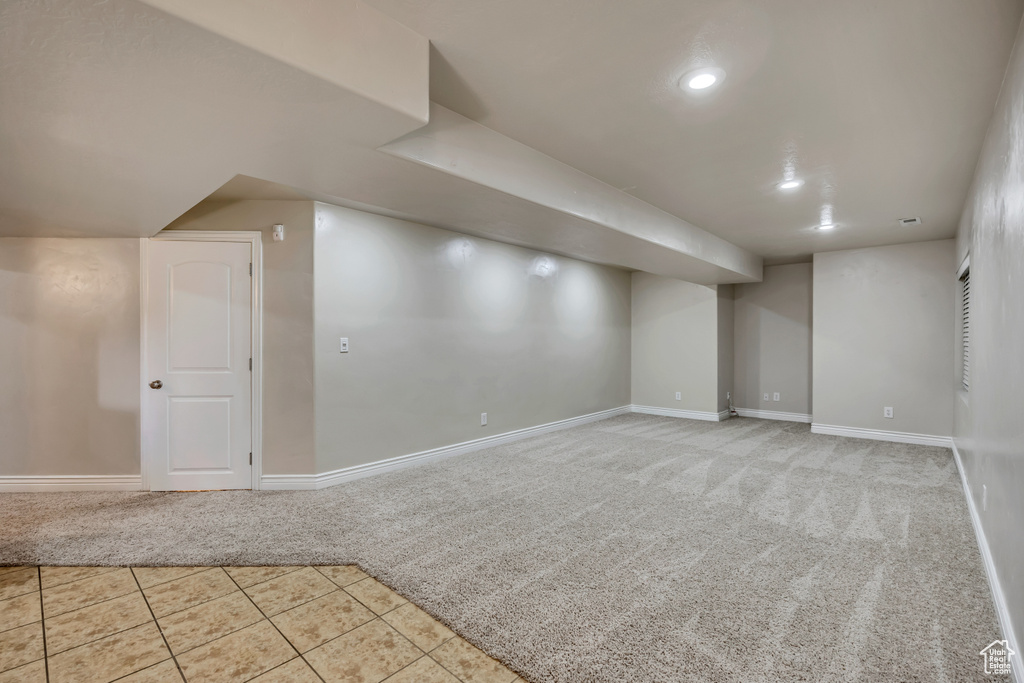 Finished below grade area with baseboards, tile patterned floors, carpet floors, and recessed lighting