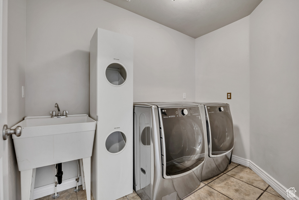 Washroom featuring separate washer and dryer, tile patterned floors, and baseboards