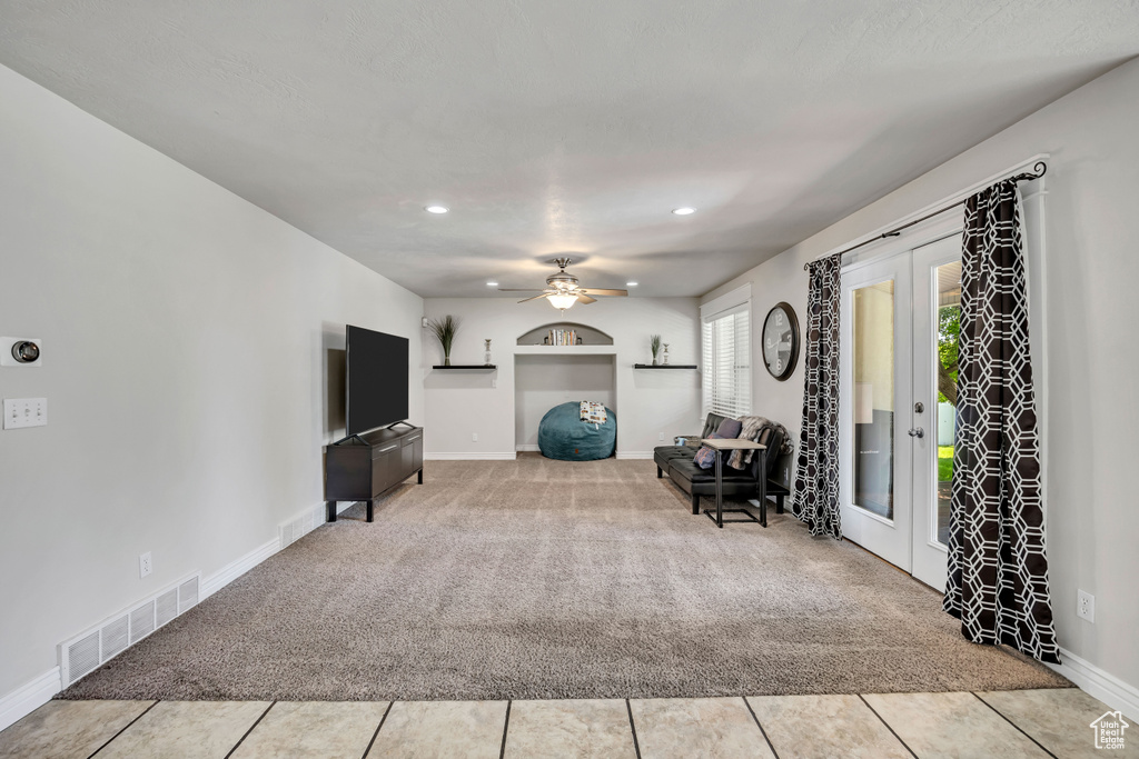 Carpeted living area with french doors, a ceiling fan, recessed lighting, baseboards, and tile patterned floors