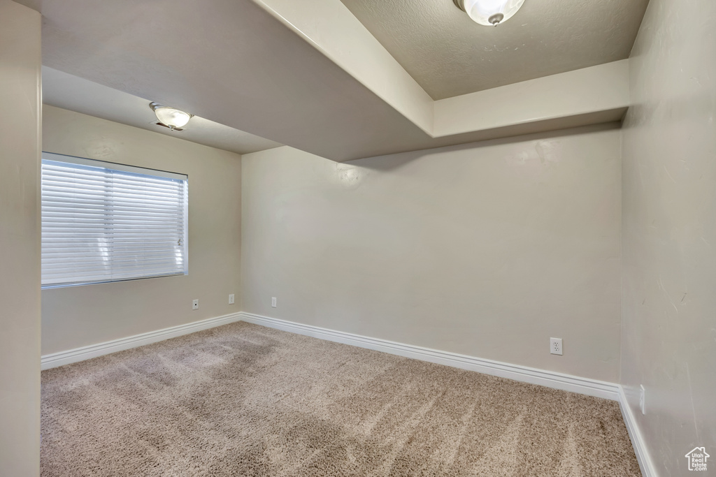 Carpeted spare room with baseboards