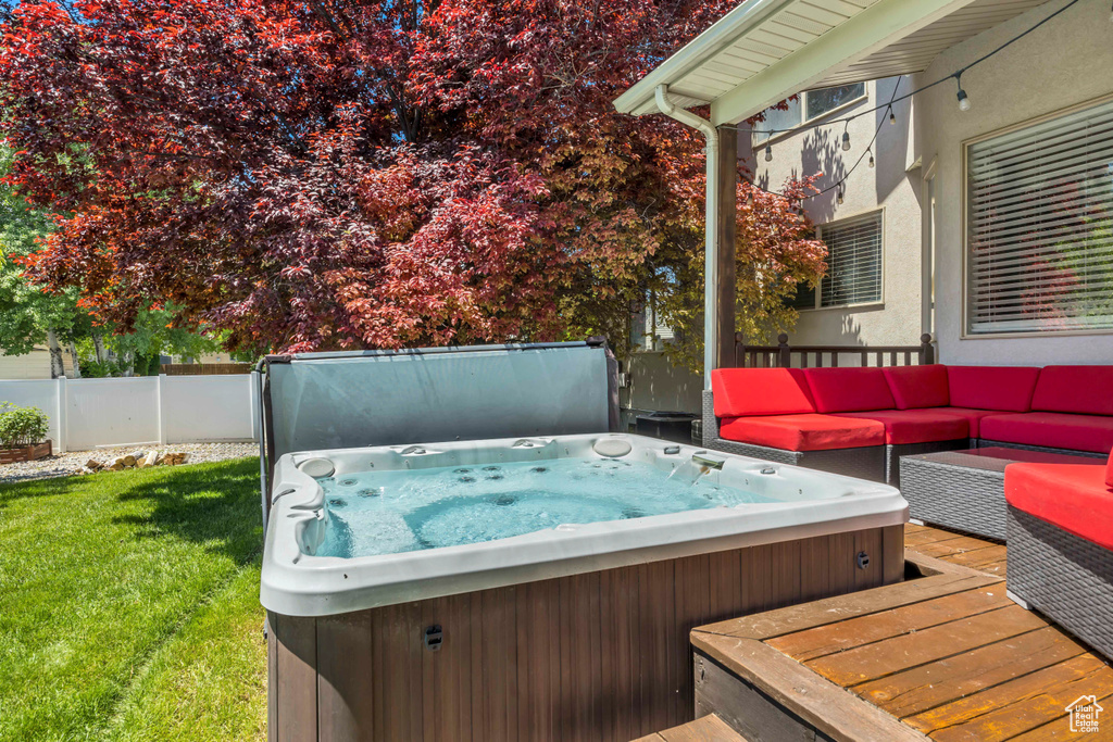 Deck with a covered hot tub and an outdoor hangout area