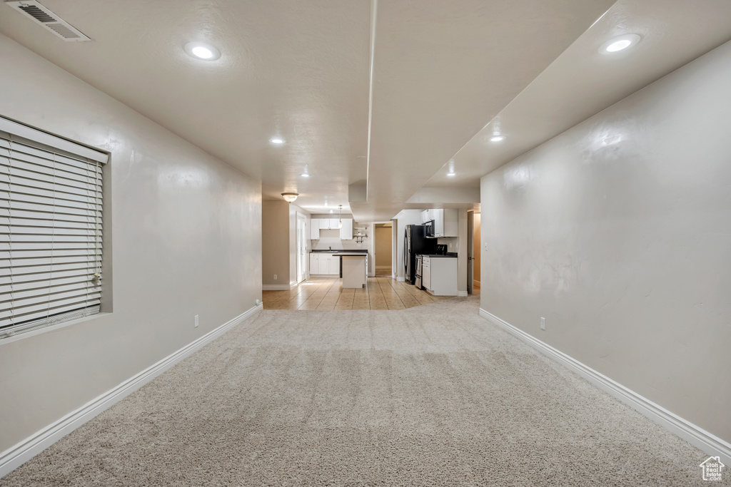 Unfurnished living room featuring recessed lighting, light carpet, and baseboards