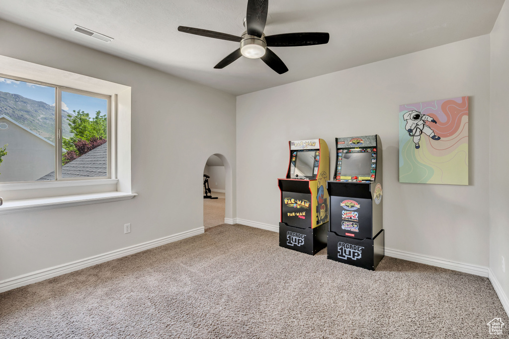 Misc room featuring carpet, ceiling fan, baseboards, and arched walkways