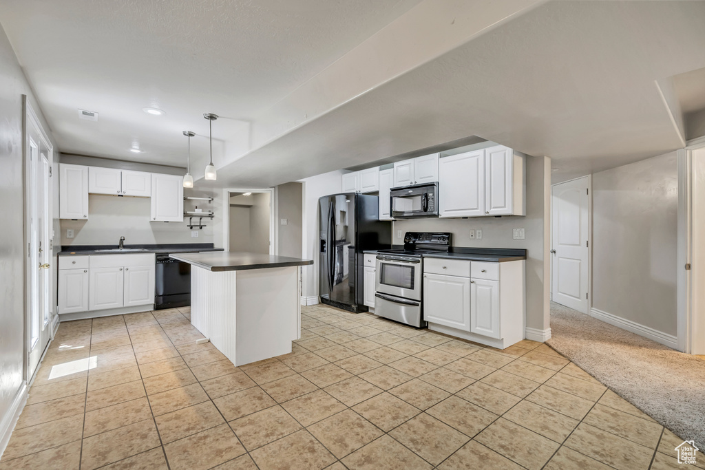 Kitchen with black appliances, a sink, light tile patterned floors, dark countertops, and white cabinets