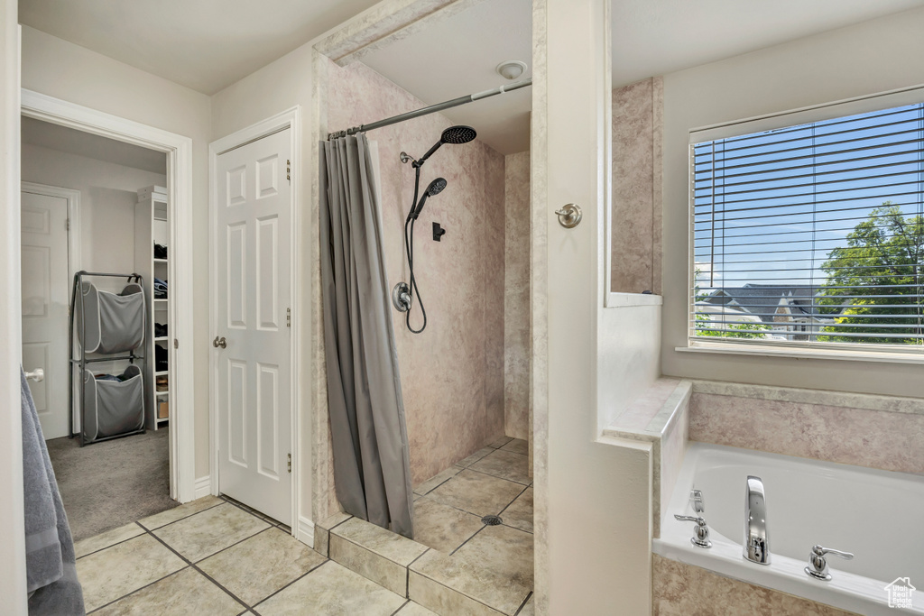 Bathroom featuring a stall shower, a garden tub, and tile patterned floors