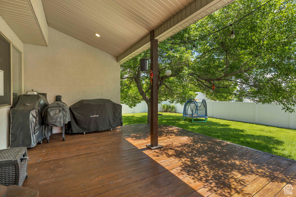 Wooden deck with a trampoline and area for grilling