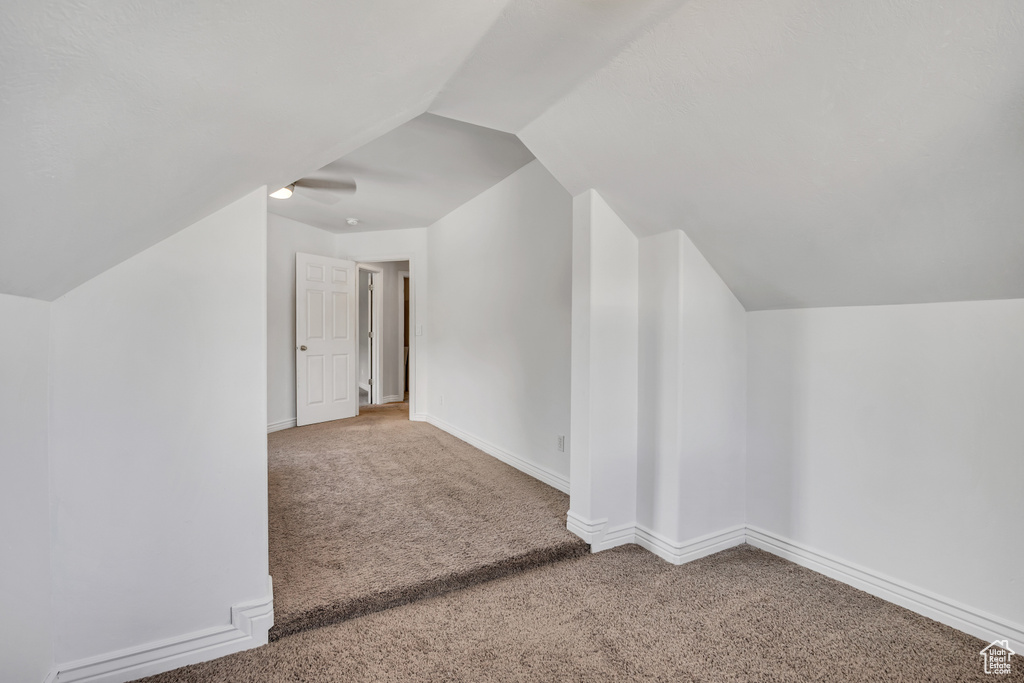 Additional living space with carpet floors, vaulted ceiling, and baseboards