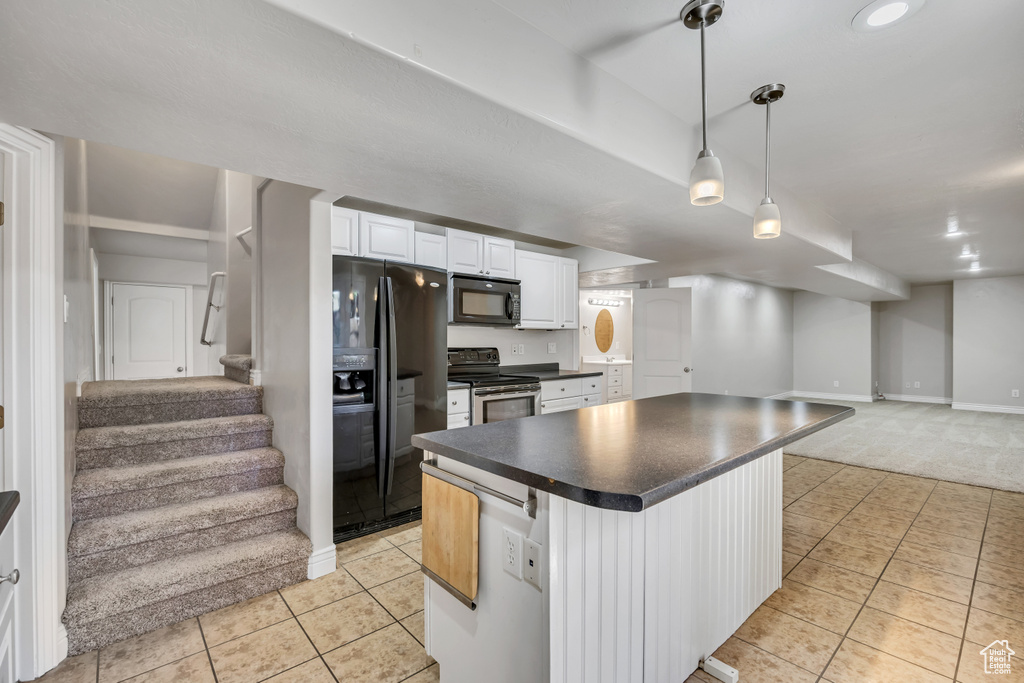 Kitchen with black appliances, open floor plan, light tile patterned flooring, and dark countertops