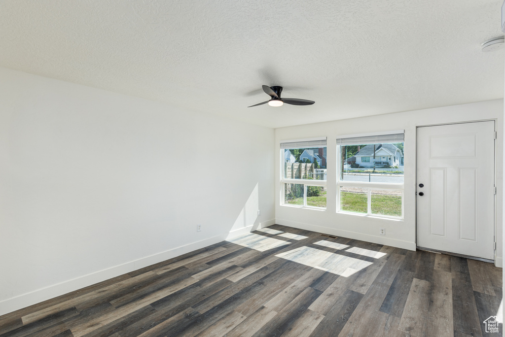 Foyer entrance featuring a ceiling fan, baseboards, dark wood-type flooring, and a textured ceiling
