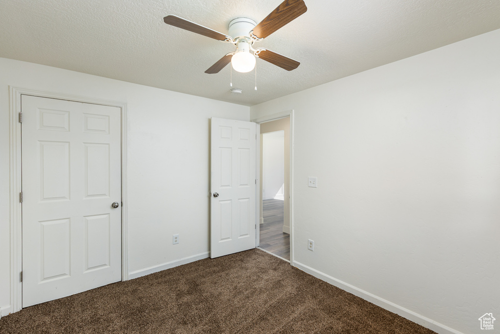 Unfurnished bedroom featuring carpet floors, baseboards, and a ceiling fan