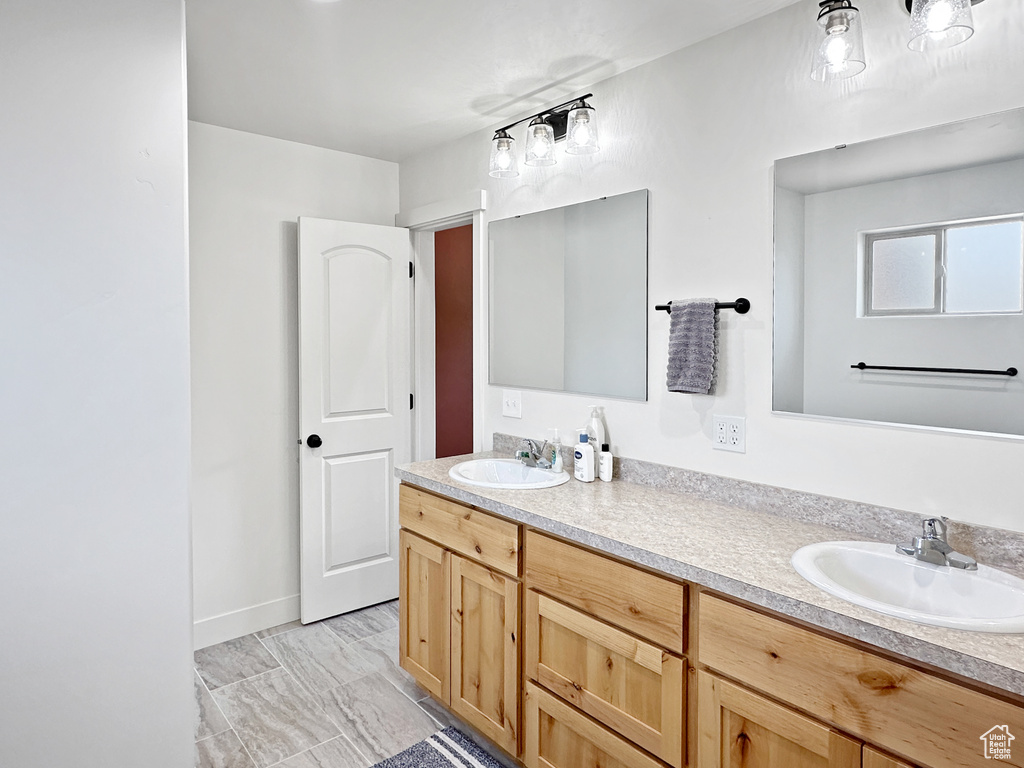 Full bathroom featuring double vanity and baseboards