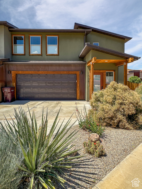 View of front of house featuring stucco siding, driveway, and an attached garage