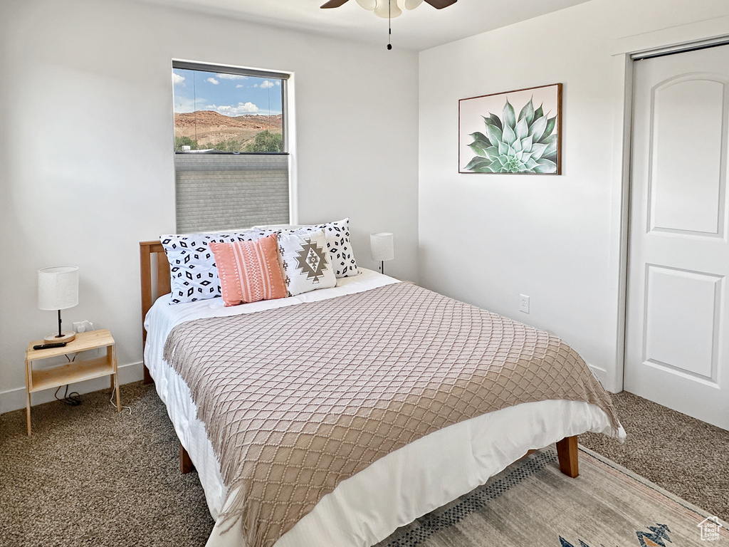 Carpeted bedroom with a ceiling fan