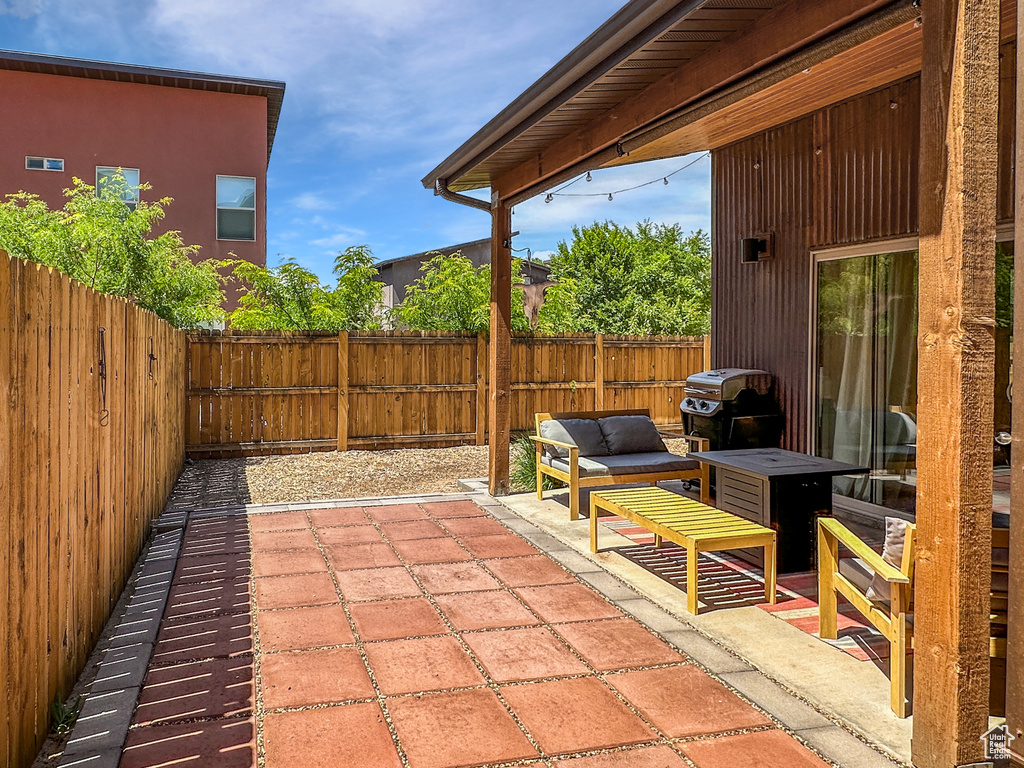 Fenced backyard featuring a patio, a grill, and an outdoor hangout area