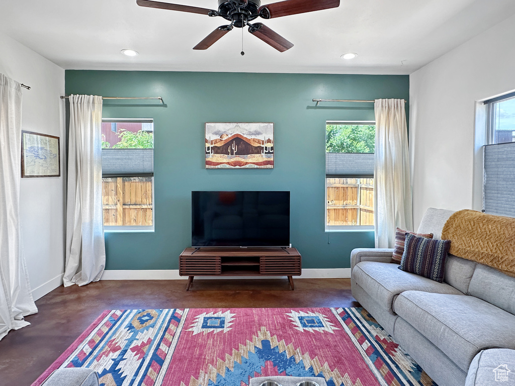 Living room with plenty of natural light, baseboards, finished concrete flooring, and recessed lighting