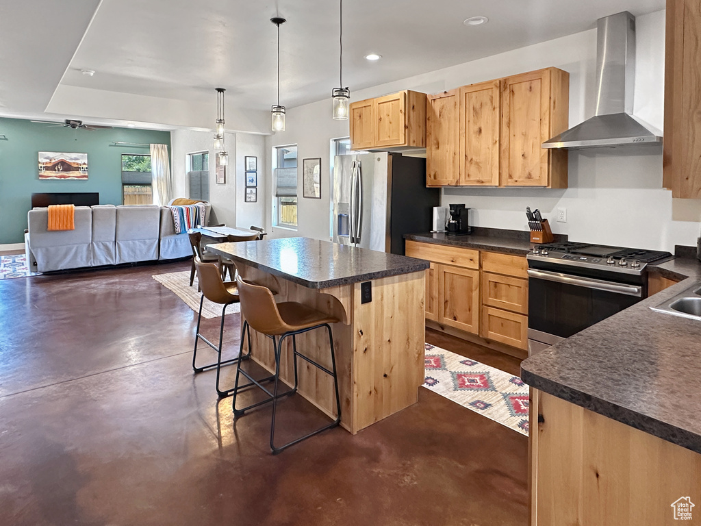 Kitchen featuring wall chimney exhaust hood, appliances with stainless steel finishes, concrete floors, dark countertops, and recessed lighting