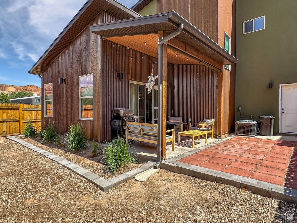 Rear view of property with a patio, central air condition unit, and an outdoor hangout area