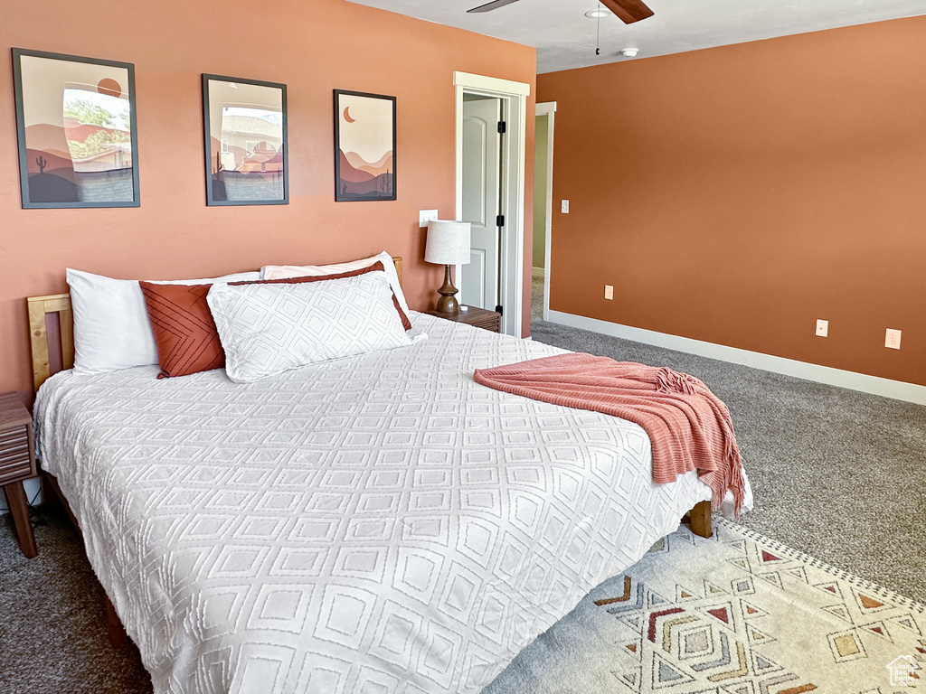 Carpeted bedroom with ceiling fan and baseboards