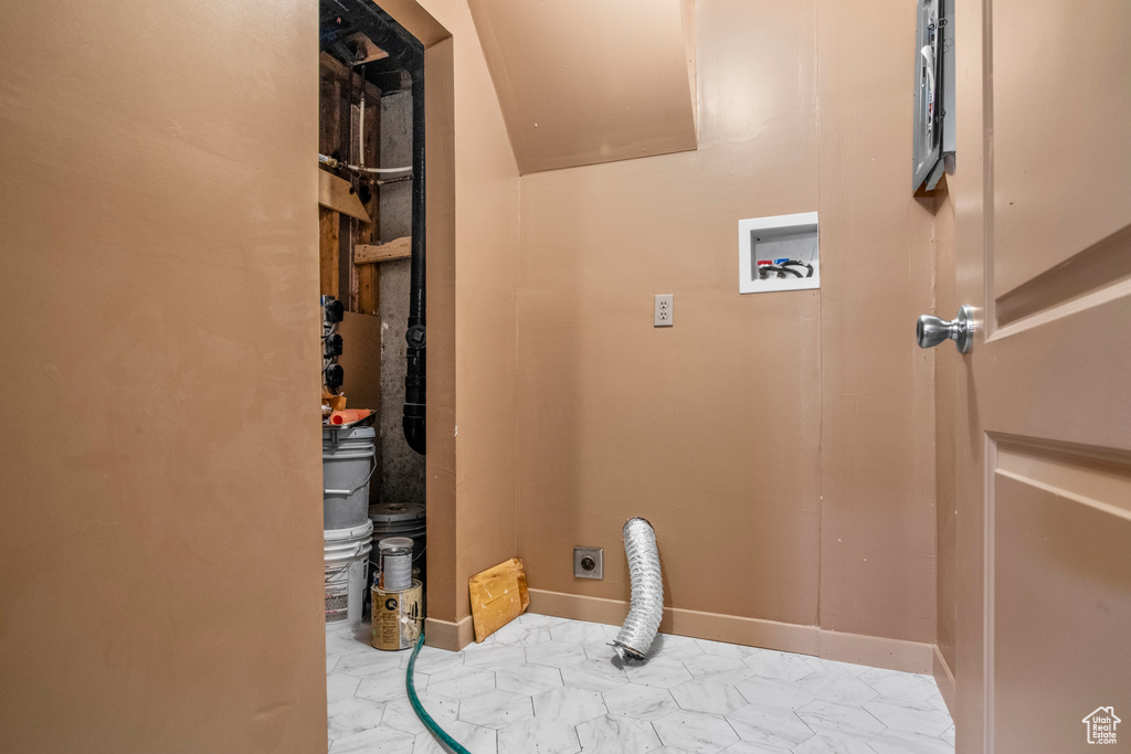 Laundry room with electric dryer hookup, hookup for a washing machine, marble look tile flooring, and baseboards