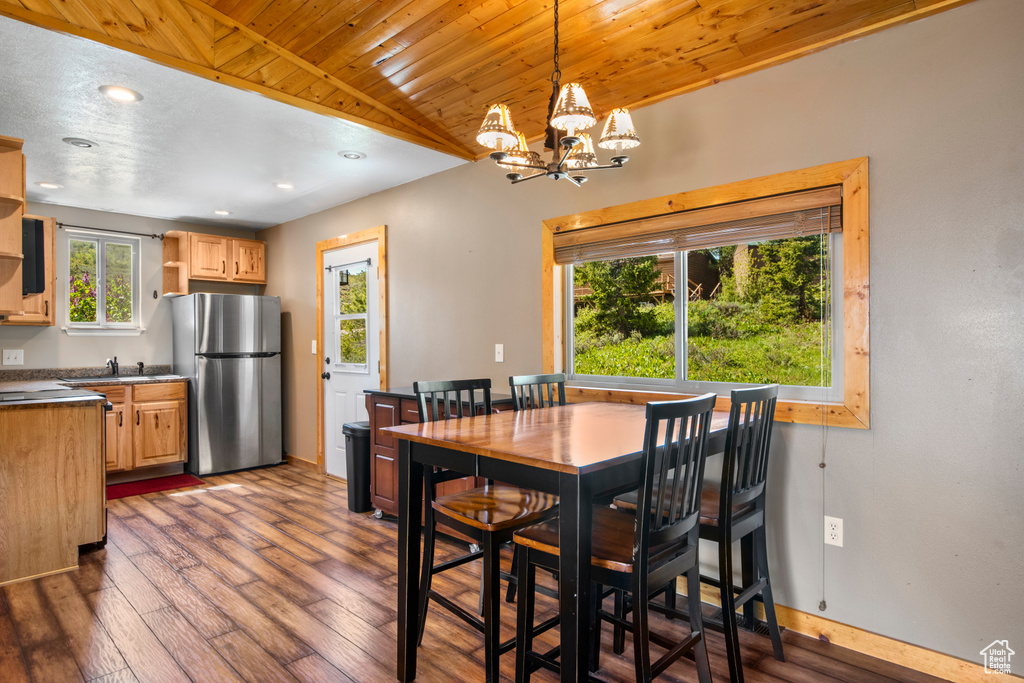 Dining space with a chandelier, wooden ceiling, dark wood-type flooring, baseboards, and recessed lighting