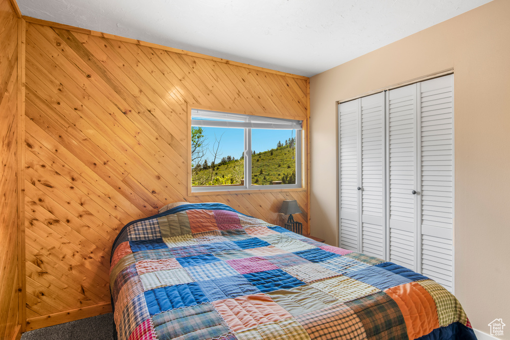 Bedroom with wood walls and a closet