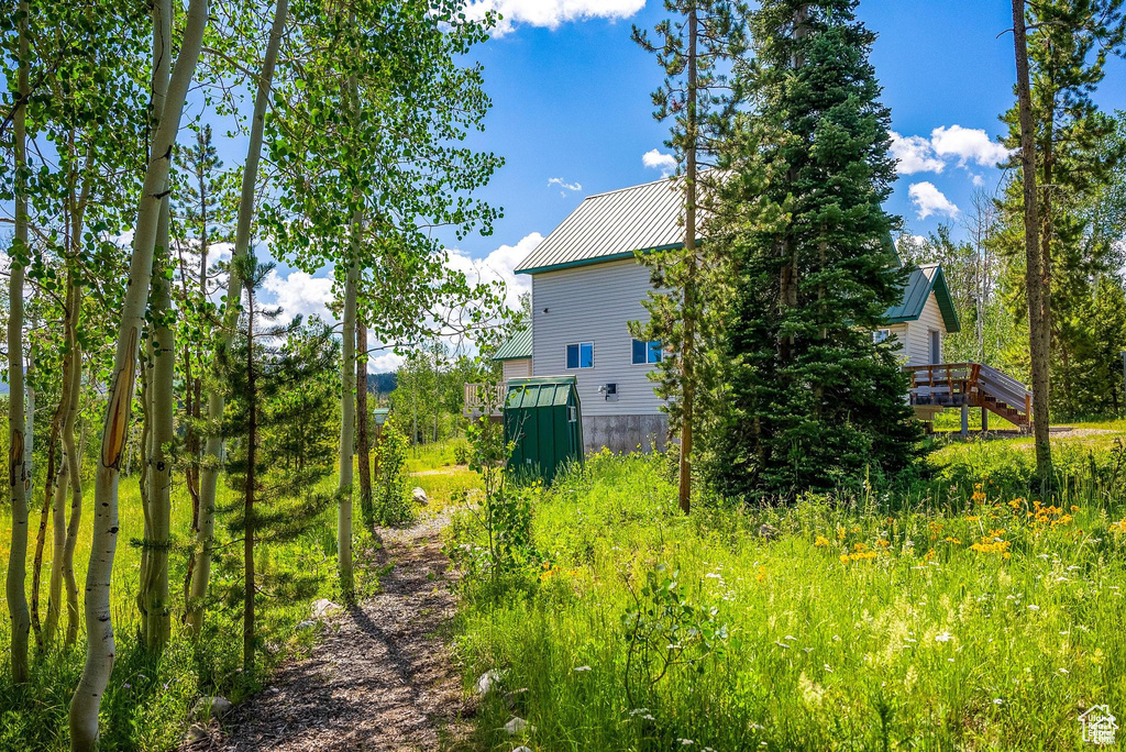 View of home\\\'s exterior with metal roof and a wooden deck